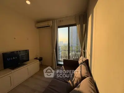 Cozy living room with balcony view, modern sofa, and wall-mounted TV in a sunlit apartment.