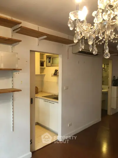 Charming apartment with elegant chandelier and cozy kitchen space.