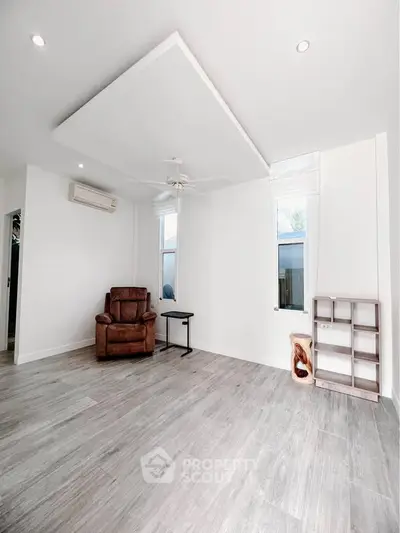 Spacious minimalist living room with modern flooring and ceiling fan