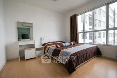 Modern bedroom with large window and stylish decor in urban apartment