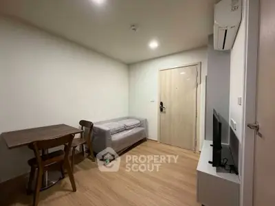 Modern living room with minimalist furniture and wooden flooring in a cozy apartment.