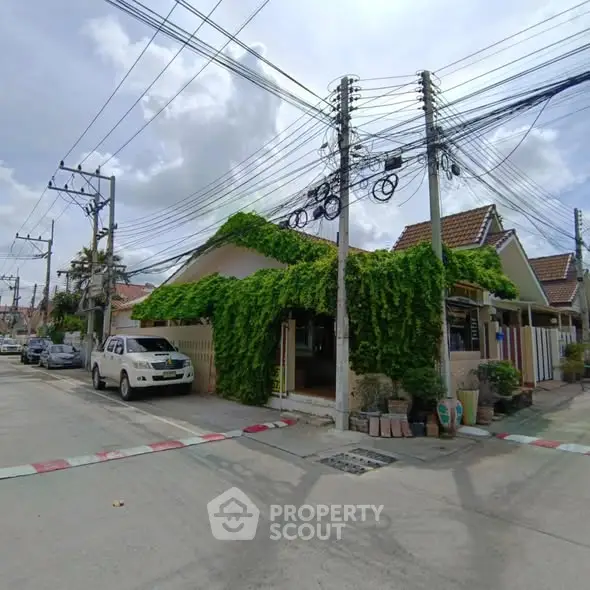 Charming residential house with lush greenery on a quiet street, perfect for serene living.