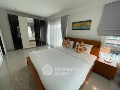 Spacious bedroom with modern decor and large windows in a stylish home.