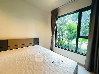 Cozy bedroom with large window and garden view, featuring a comfortable bed and elegant curtains.