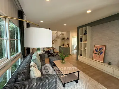 Stylish living room with modern decor and open layout, featuring large windows and elegant furnishings.