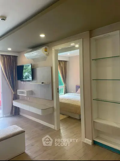 Modern apartment interior with open living area and bedroom view