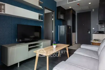 Modern living room with sleek furniture and open kitchen layout in a stylish apartment.