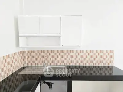 Modern kitchen with sleek black countertop and stylish backsplash