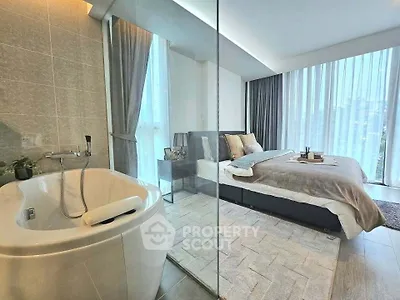 Luxurious bedroom with glass-enclosed bathtub and floor-to-ceiling windows