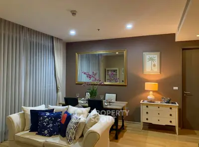 Elegant living room with cozy sofa, dining table, and ambient lighting in modern apartment.