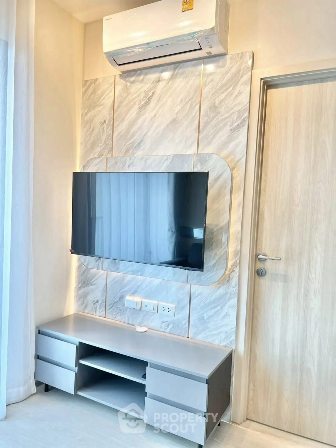 Modern living room with sleek TV setup and air conditioning