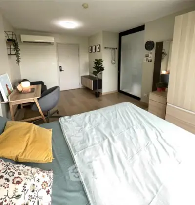 Spacious bedroom with modern decor and cozy seating area, perfect for relaxation.