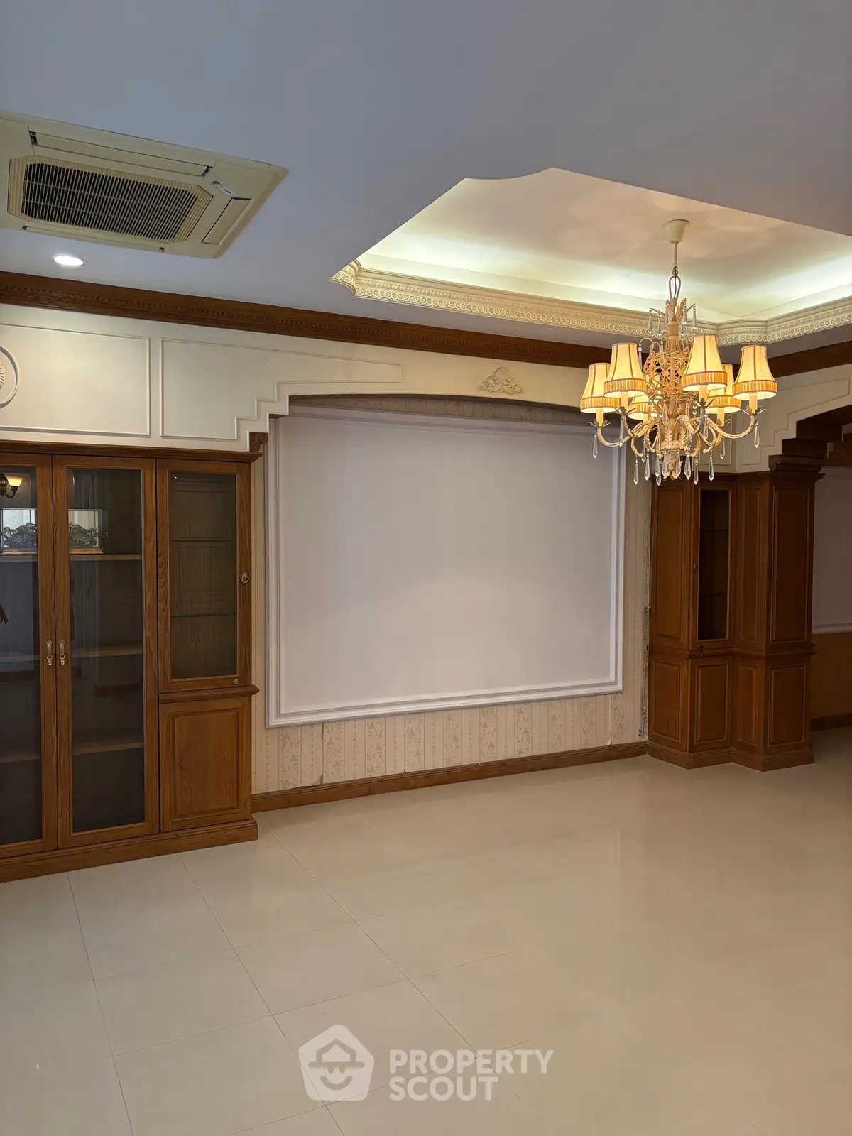 Elegant living room with chandelier and wooden cabinetry, featuring a classic design and spacious layout.