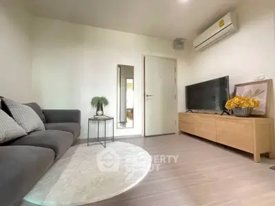 Modern living room with sleek furniture and stylish decor, featuring a cozy sofa and flat-screen TV.