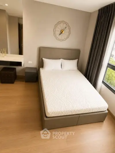Modern bedroom with stylish decor and large window for natural light.