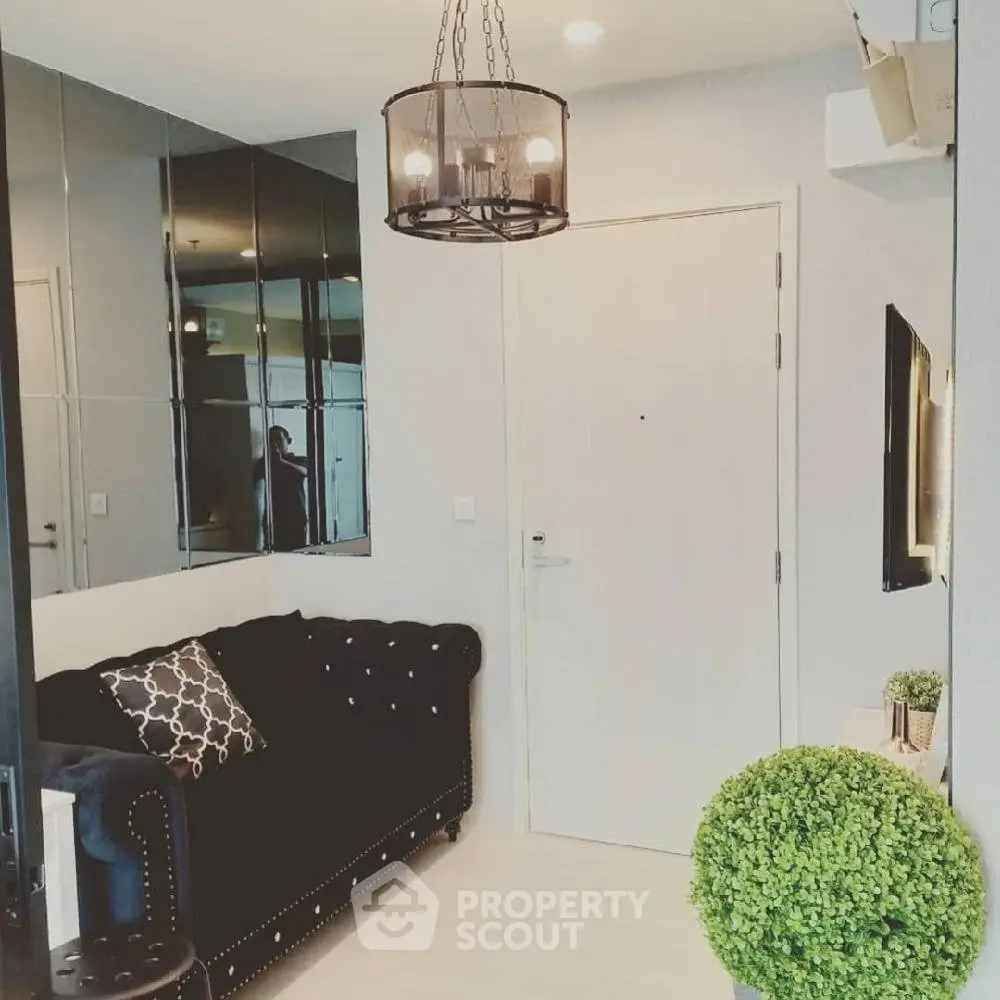 Chic modern living room with black sofa, elegant lighting, and stylish decor.