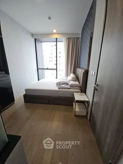 Modern bedroom with large window and stylish decor in urban apartment