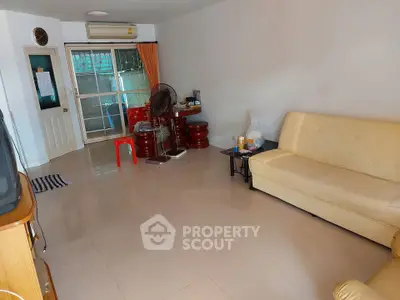 Spacious living room with beige sofa and modern decor in a cozy apartment.