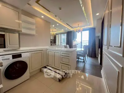 Luxurious modern kitchen with washing machine and elegant dining area, featuring chic lighting and stylish decor.