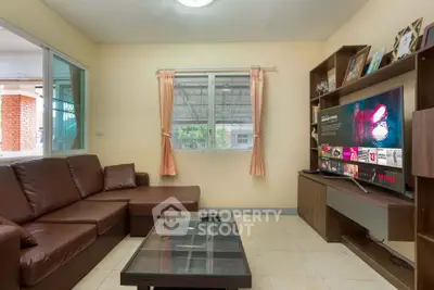 Cozy living room with brown leather sofa and modern TV setup