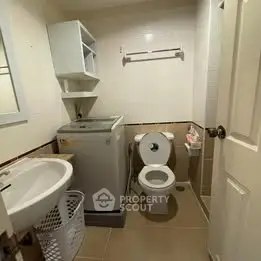 Compact bathroom with washing machine and modern fixtures