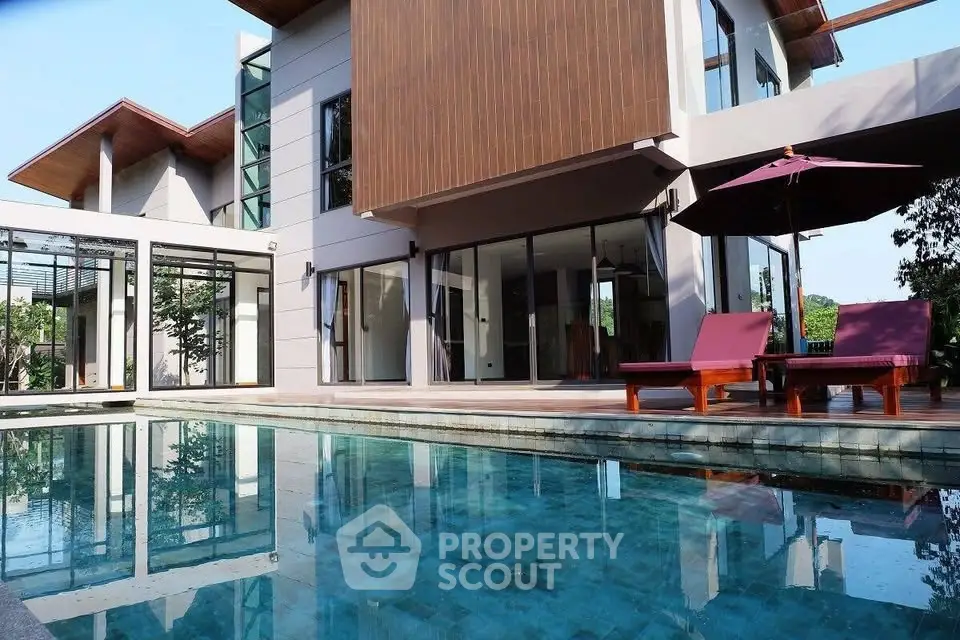 Luxurious modern home with stunning poolside view and elegant architecture.