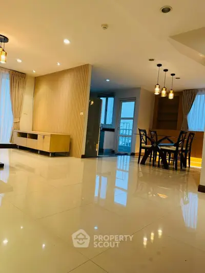 Spacious modern living room with elegant dining area and stylish lighting fixtures.