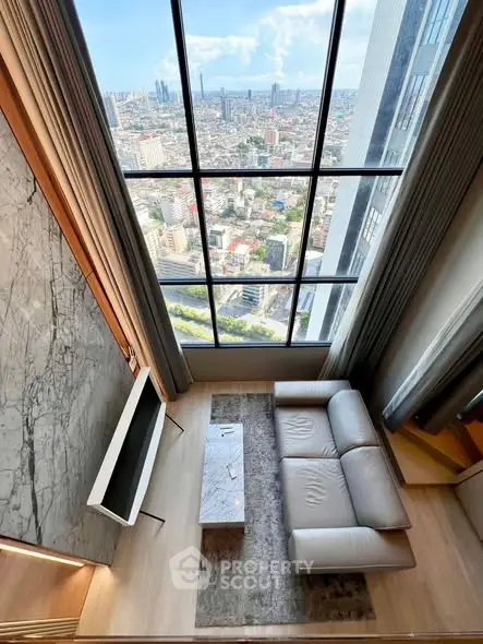 Luxurious high-rise living room with stunning city view through floor-to-ceiling windows.