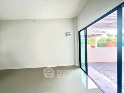 Spacious modern living room with large sliding glass doors opening to a patio area.