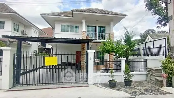Charming two-story house with gated entrance and balcony, perfect for family living.