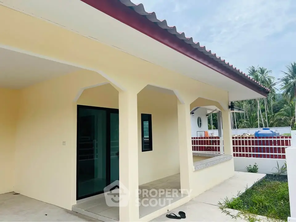 Charming single-story home with covered porch and tropical surroundings, perfect for serene living.