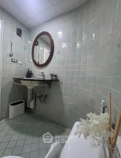 Charming bathroom with vintage tile design and round mirror