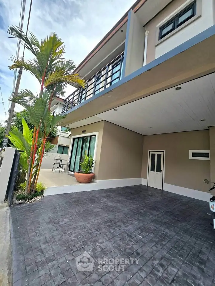 Modern two-story house with spacious driveway and balcony, perfect for family living.