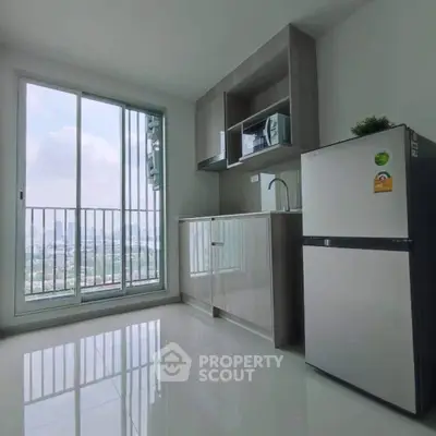 Modern kitchen with sleek cabinets and city view from large window.