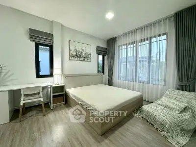 Modern bedroom with large windows, minimalist decor, and cozy ambiance.
