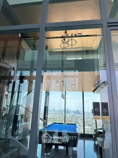 Luxurious high-rise apartment with stunning city view and modern interior design featuring a pool table.