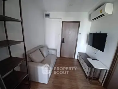 Cozy living room with modern furniture and wall-mounted TV in a stylish apartment.