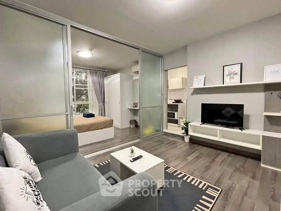 Modern apartment interior with cozy living room and bedroom, featuring sleek furniture and stylish decor.