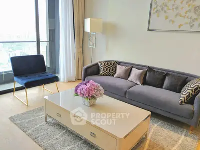 Elegant living room with modern furniture and large window offering city views.