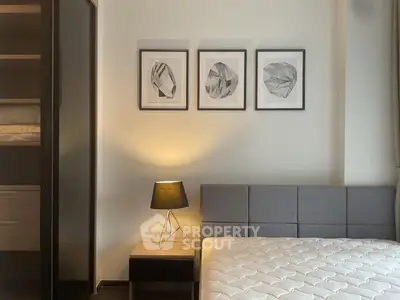 Modern bedroom with stylish decor and cozy lighting, featuring a comfortable bed and elegant artwork.