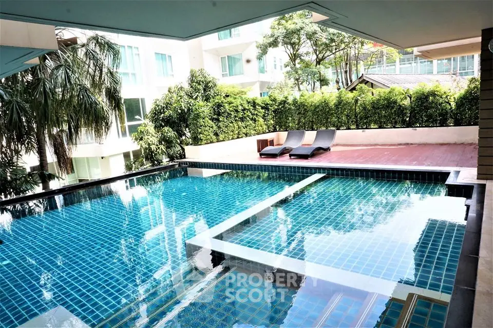 Luxurious pool area with modern design and lush greenery in a premium residential complex.