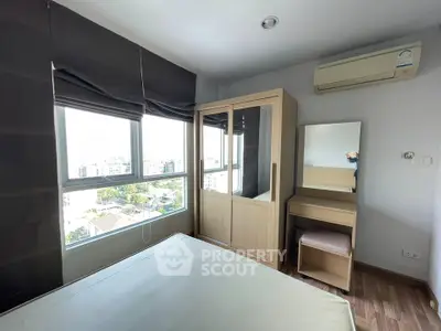 Bright bedroom with large windows and modern furniture in a high-rise apartment.