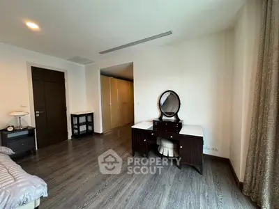 Spacious bedroom with elegant wooden furniture and ample natural light.