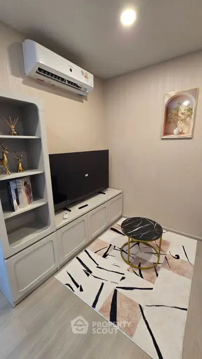 Modern living room with sleek TV unit, stylish decor, and air conditioning for comfort.