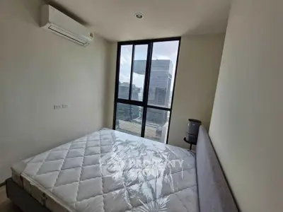 Modern bedroom with large window offering stunning city view, featuring a comfortable bed and air conditioning.