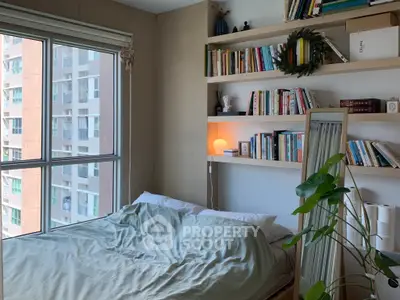 Cozy bedroom with large window and bookshelf, perfect for relaxation and reading.