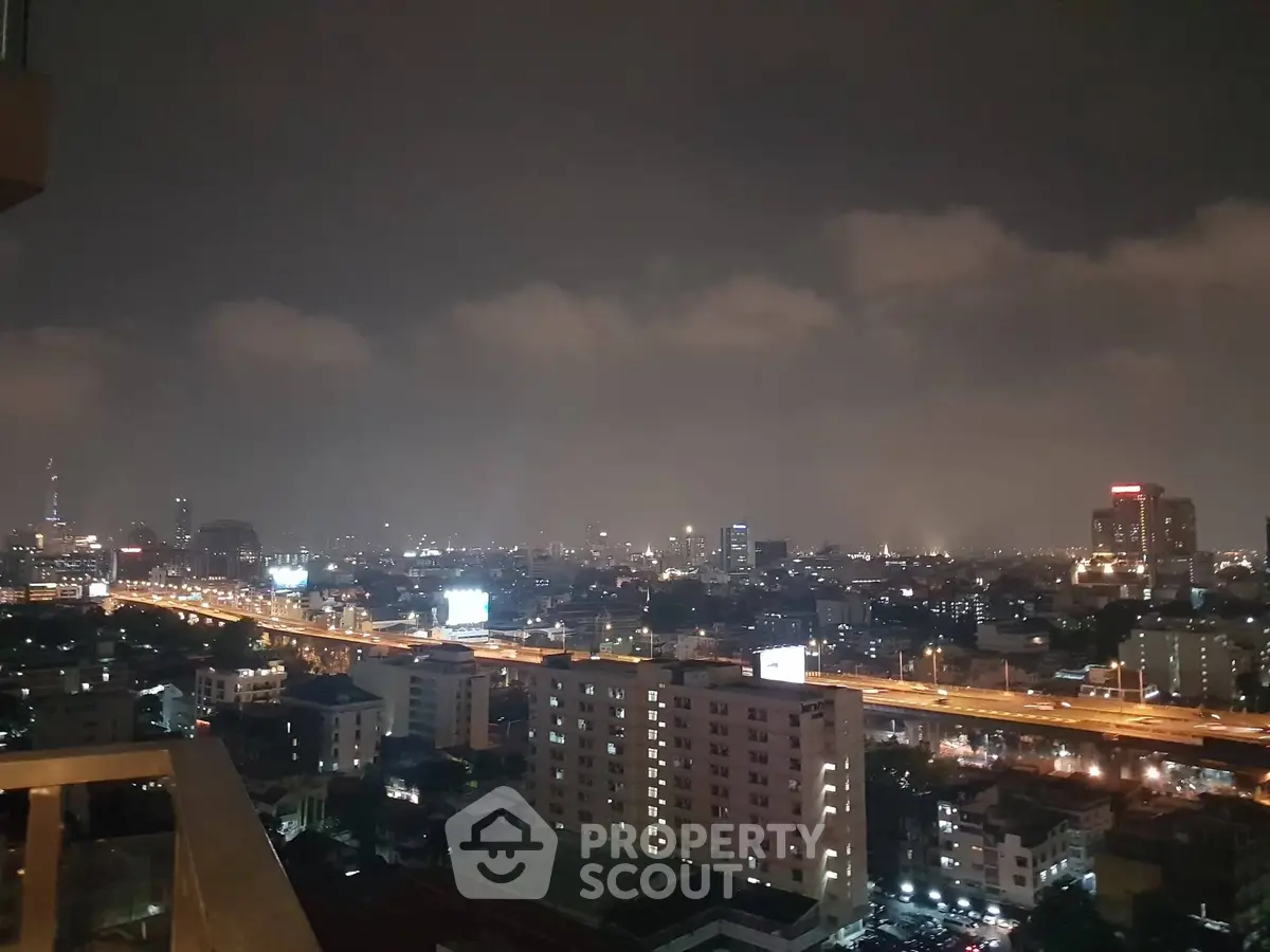 Stunning cityscape view from high-rise balcony at night with illuminated skyline.