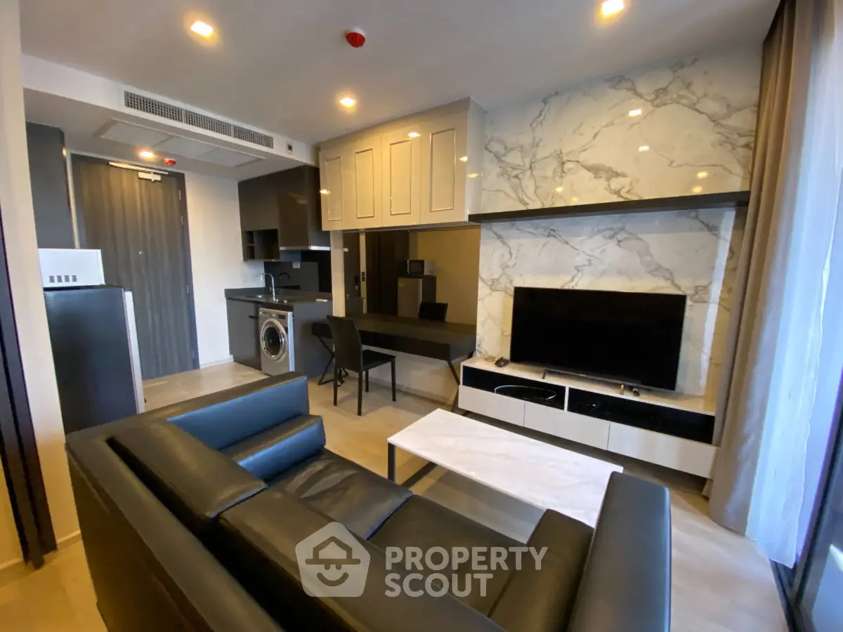 Modern living room with sleek furniture and integrated kitchen appliances in a stylish apartment.