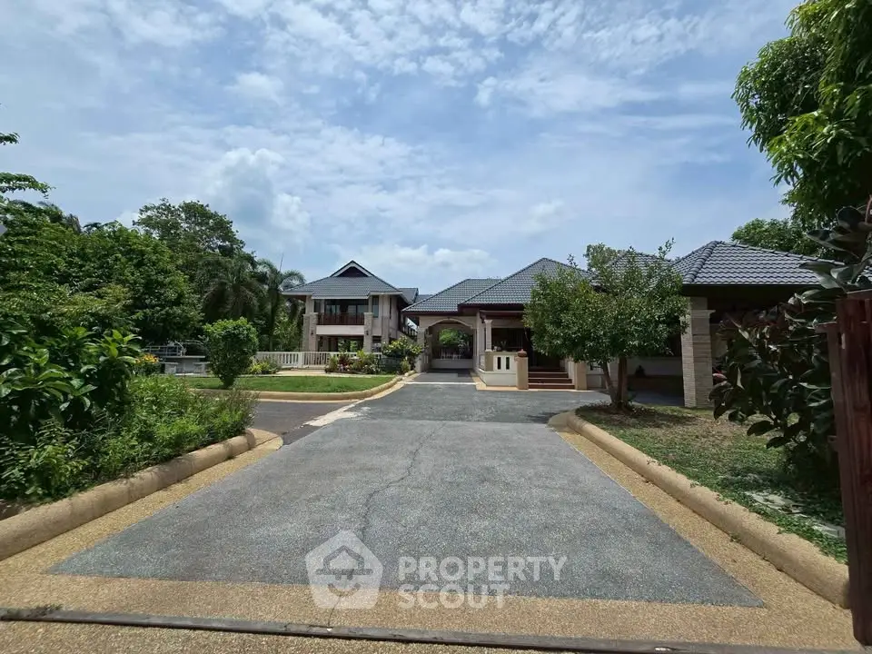 Stunning modern home with lush greenery and spacious driveway, perfect for serene living.