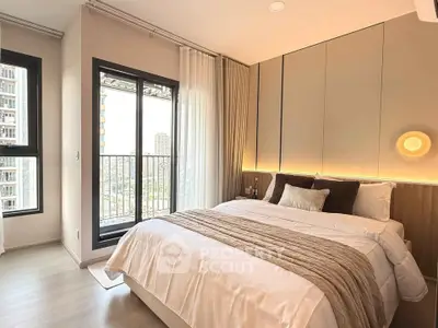 Luxurious bedroom with modern decor and city view from balcony in high-rise apartment.